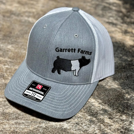 Customized Richardson 112 with an embroidered graphic of a Hampshire pig and the farm name "Garrett Farms" embroidered above.