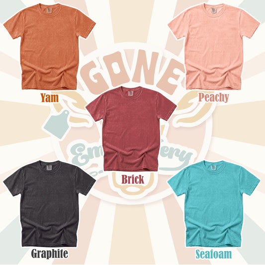 Collection of plain t-shirts in various colors with labels on a patterned background