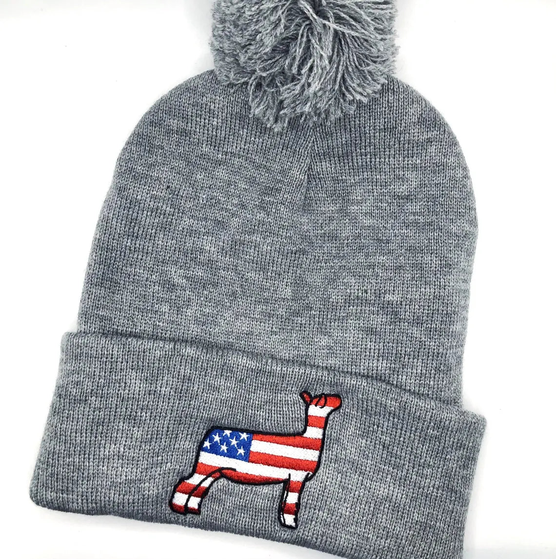 Grey knit beanie with an embroidered graphic of a show lamb with the American flag pattern.