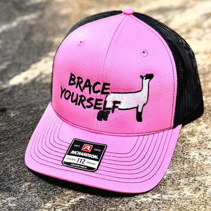 Pink and black cap with a show sheep design reading 'Brace Yourself' text.