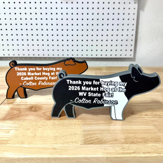 3D printed Hampshire and Duroc show pig figures thanking county fair and auction supporters.