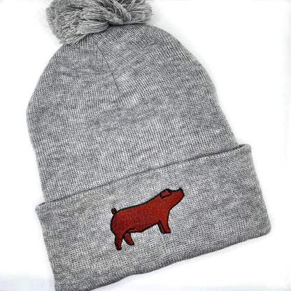 Comfortable and warm winter beanie hat featuring an embroidered red duroc show pig.