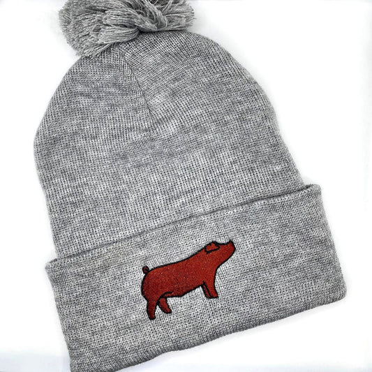 Comfortable and warm winter beanie hat featuring an embroidered red duroc show pig.