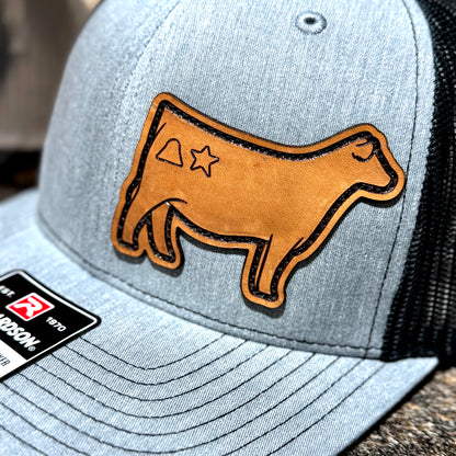 Close up of a show heifer with brand leather patch hat.