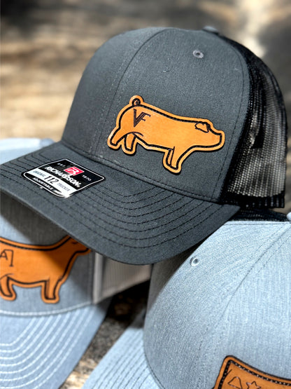 Dark grey cap featuring a genuine leather show pig patch with a brand on the hip.