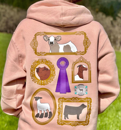 Pink hoodie with livestock animal illustrations including show steer, heifer, goat, pig, and sheep in vintage farms along with a ribbon and belt buckle. 