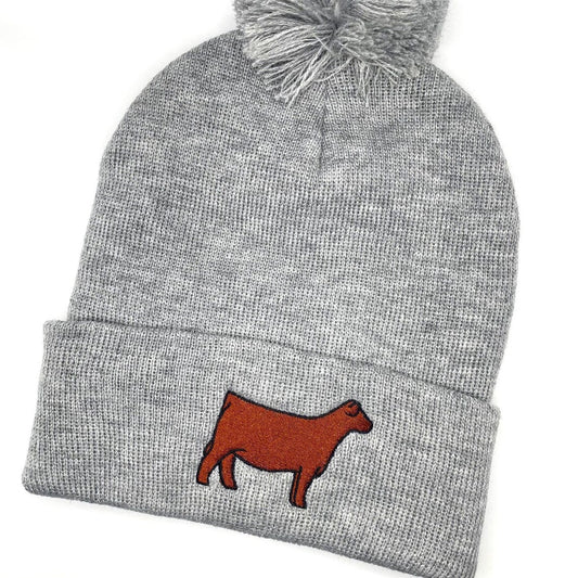 Comfy winter beanie hat with a pompom and high quality embroidery of a Red Angus show heifer. 