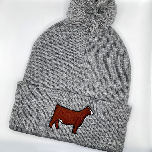 Comfy winter beanie hat with high quality embroidery of a red Simmental heifer with a blaze face.