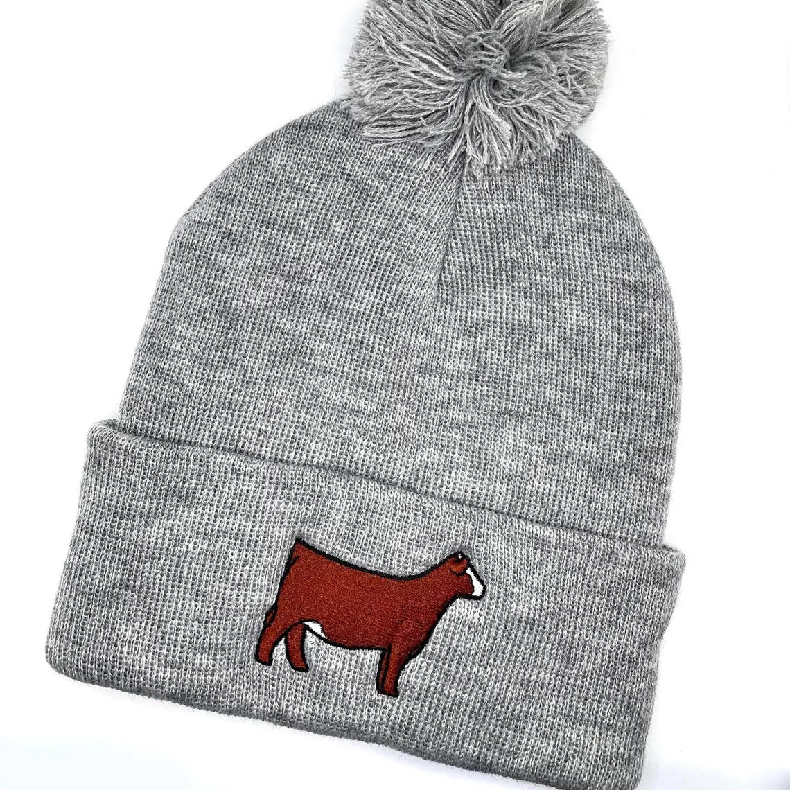 Comfy winter beanie hat with high quality embroidery of a red Simmental heifer with a blaze face.