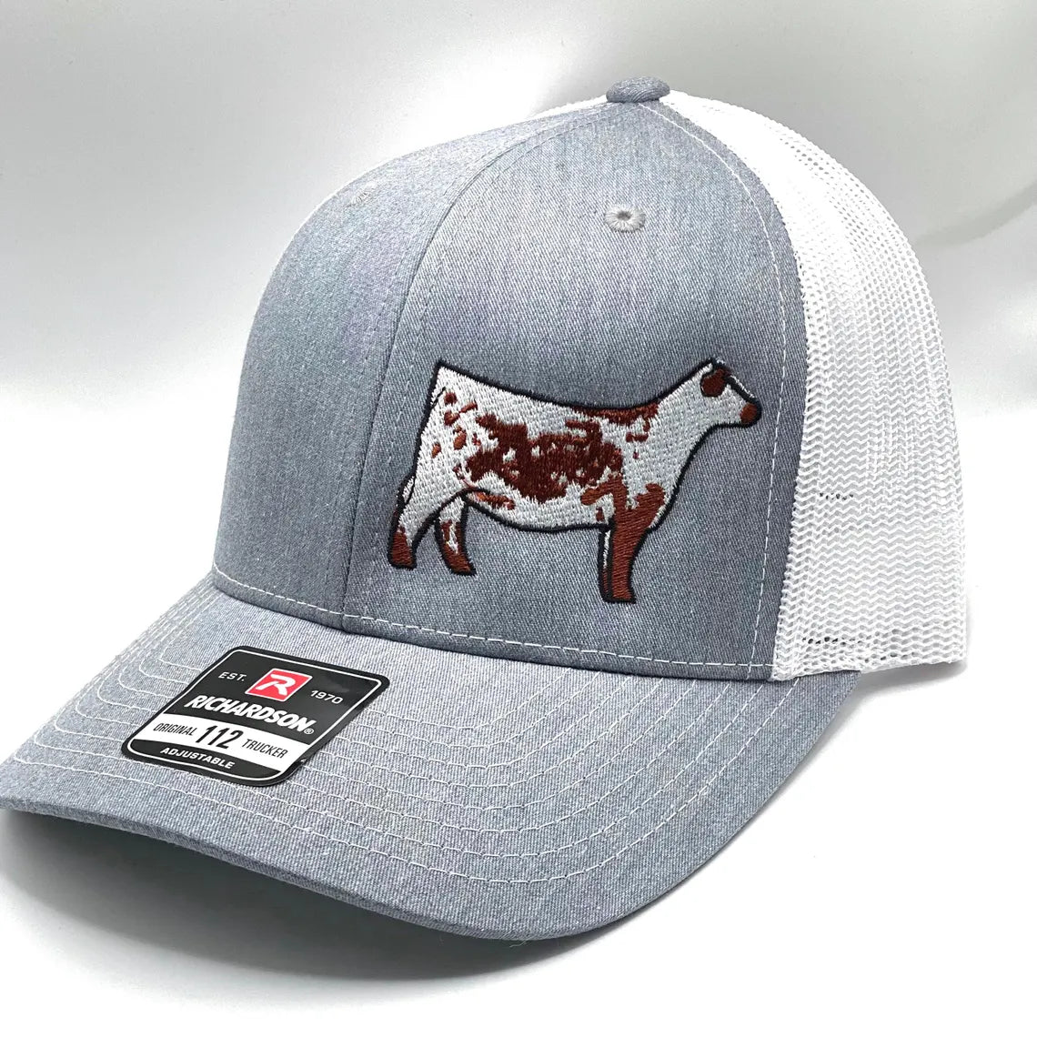 Red and white trucker hat with a red Speckle Park embroidered on the front. The hat has a Richardson 112 logo on the side.