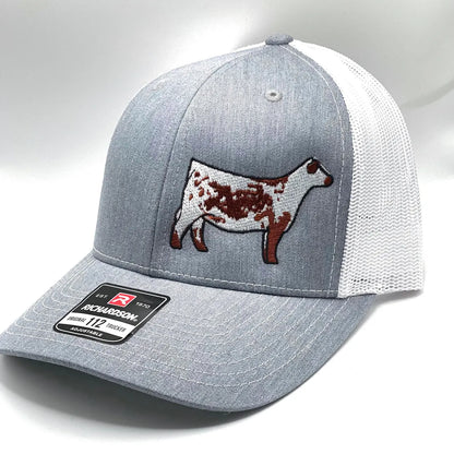 Red and white trucker hat with a red Speckle Park embroidered on the front. The hat has a Richardson 112 logo on the side.