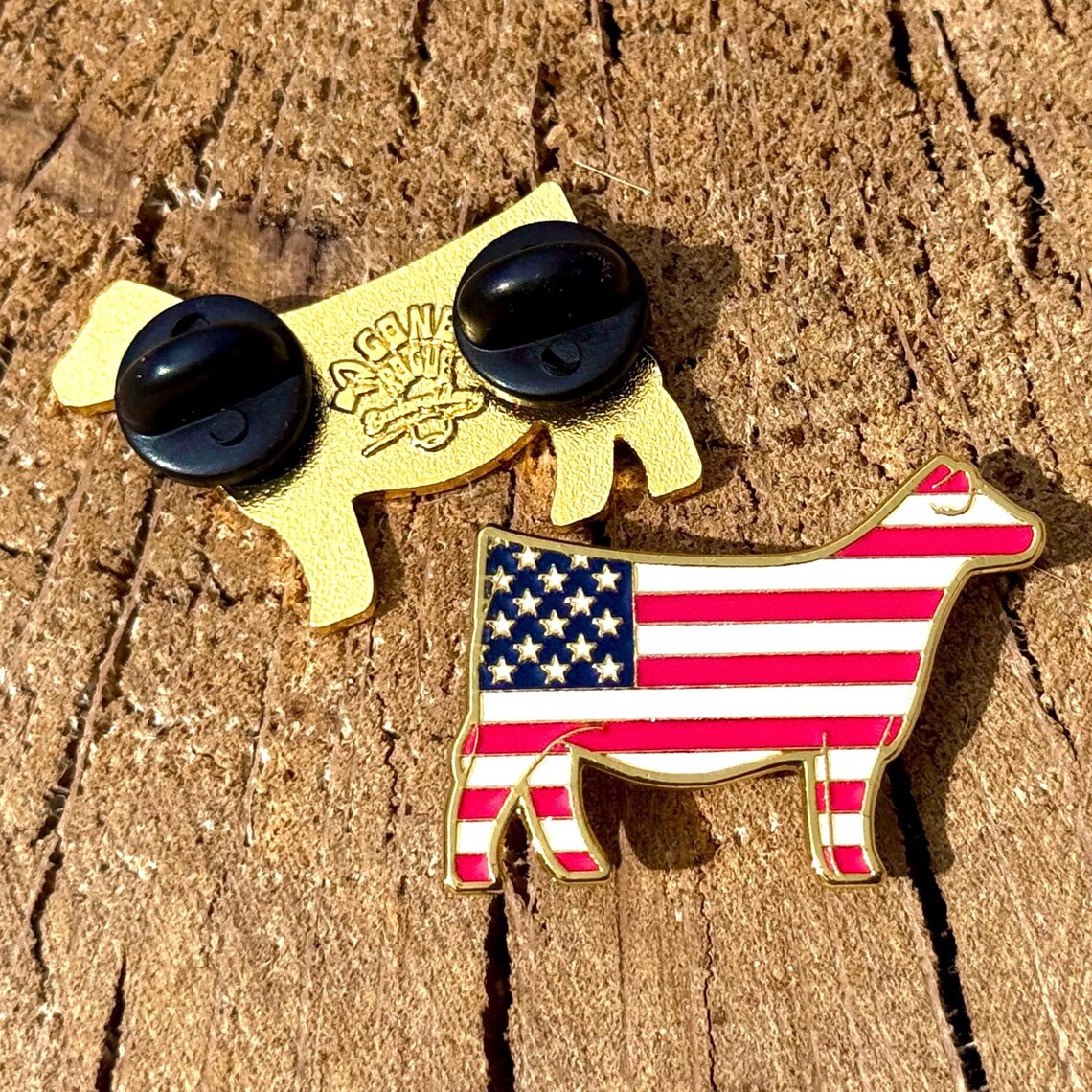 Show cattle pin with American flag design on a wooden surface