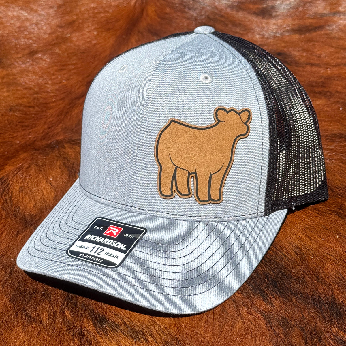 Heather grey and black Richardson 112 hat featuring a leather patch of a show steer.