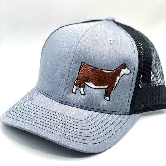 Embroidered Hereford trucker hat featuring a detailed cattle design. Breathable mesh back with an adjustable snapback closure for a comfortable fit. Perfect for ranchers, cattle show enthusiasts, and livestock lovers.